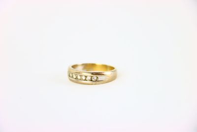 gros plan d'une bague en or sur une surface blanche