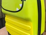 une valise jaune ornée d'un smiley, posée sur une boîte