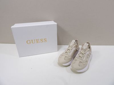 Des chaussures dans une boîte et une paire de chaussures posée sur une table