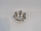 a silver plate with a flower design on it on a white surface