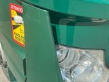 a green garbage can with a warning sticker on it