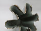 a green vase with a flower shaped design on it