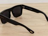 sunglasses on a wooden table with a white wall in the background