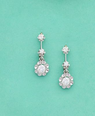 une paire de boucles d'oreilles en diamant sur fond turquoise