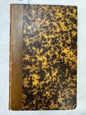 un vieux livre posé sur une table couverte de taches marron et noires