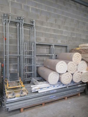 de nombreux rouleaux de tissu empilés sur une palette dans un entrepôt