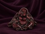 a small buddha statue sitting on top of a purple cloth