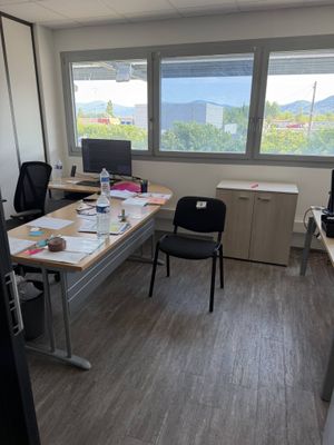 a room with a desk, chairs, and a computer on it