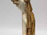 statue of a woman holding a flower in her right hand
