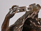 bronze statue of a man holding a cell phone to his head