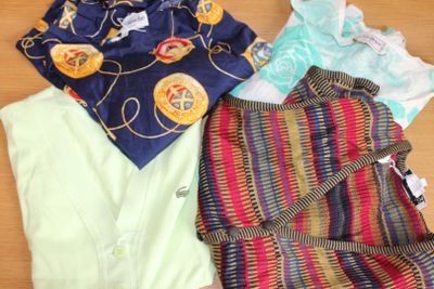 un tas de vêtements posé sur une table, à côté d'une paire de chaussures