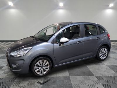 a grey citrole is parked on a checkered tile floor