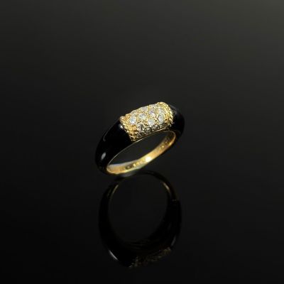 a gold ring with a black band and a white diamond