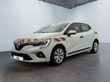 La voiture blanche est garée dans une grande pièce aux murs blancs.