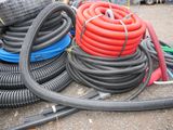 a pile of hoses sitting on the ground next to a pile of other hoses