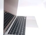 a silver laptop with a black keyboard on a white surface