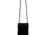 the small black bag is hanging on a white wall