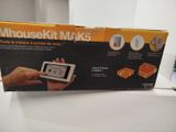 someone is holding a small electronic device in front of a box