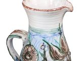 a white pitcher with a blue and green design on it
