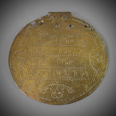 une vieille médaille d'or sur laquelle est gravé un motif