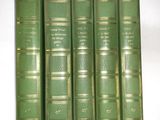four green books are lined up on a white surface