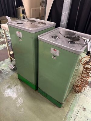 deux machines à laver vertes dans une pièce avec un rideau noir