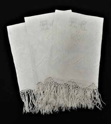 trois mouchoirs blancs à franges sur fond noir