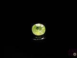 a close up of a green gems on a black surface