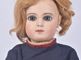 a doll that is wearing a blue shirt and red pants