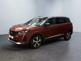 Une voiture rouge est garée dans une pièce aux murs blancs