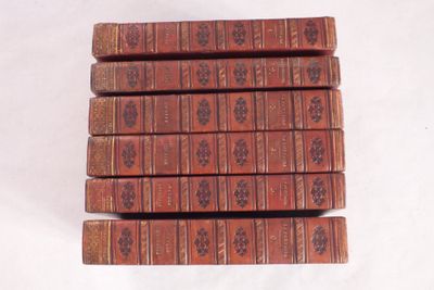 six vieux livres empilés sur une surface blanche