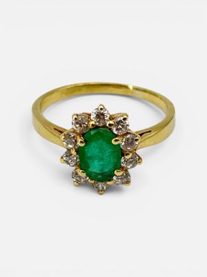 a close up of a gold ring with a green stone