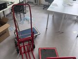 two red hand trucks sitting in the middle of a room