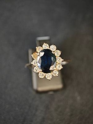 gros plan d'une bague en saphir bleu et diamant sur une surface noire
