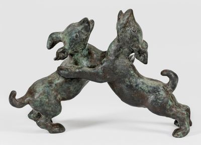 statue en bronze représentant deux chiens en train de se battre sur une surface blanche