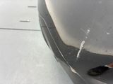 a close up of a person ' s shoe on the front of a car