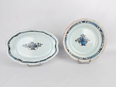 two blue and white plates with flowers on them on a white surface