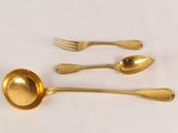 four gold spoons and a fork on a white surface