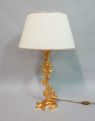 une lampe dorée munie d'un abat-jour blanc