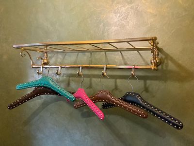 trois paires de chaussures suspendues à un porte-chaussures dans une salle de bains