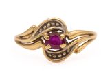 a close up of a gold ring with a ruby stone