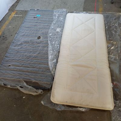 two mattresses sitting on the ground in a warehouse