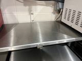 a metal shelf with a microwave on it in a kitchen