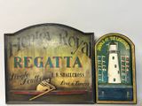 two plaques on the wall with a lighthouse in the background