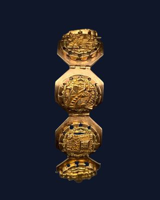 a close up of a gold object on a black background