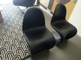 two black chairs sitting in a room with a rug on the floor