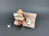 a figurine of a man sitting on a bench with a dog