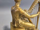statue of a woman playing a harp on a marble base