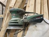 a sander that is sitting on top of a pile of wood