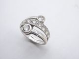 a close up of a silver ring with diamonds on a white surface